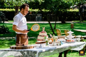 Wedding staff at Nieuw Westert, Egmond, NL, safeguarding cake from wasps with an electric paddle zapper in hand.